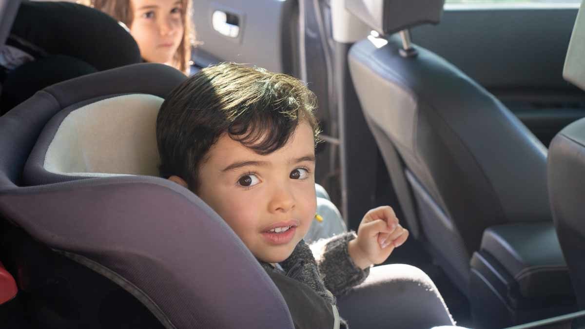 Menor sentado en el vehículo en un sistemas de retención infantil adecuado