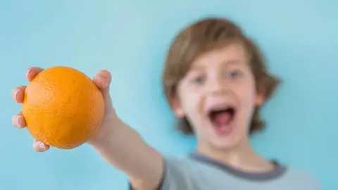 niño mostrando naranja