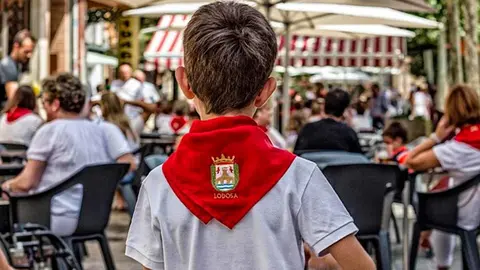 Un niño luce el pañuelico rojo con el escudo de Lodosa