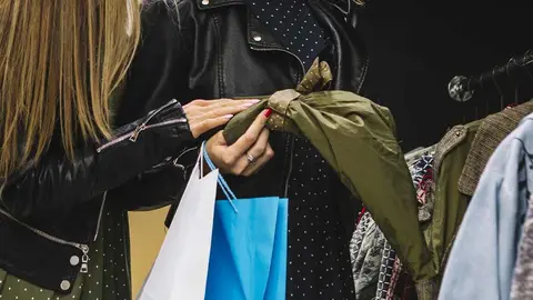 Dos mujeres cogiendo ropa de una tienda. Foto de archivo