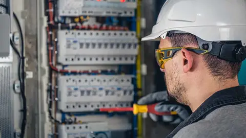 electricista revisa un cuadro eléctrico