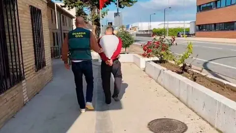 un agente de la Guardia Civil traslada al detenido durante la operación policial