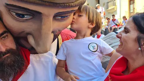 un niño besea en la cara a un gigante